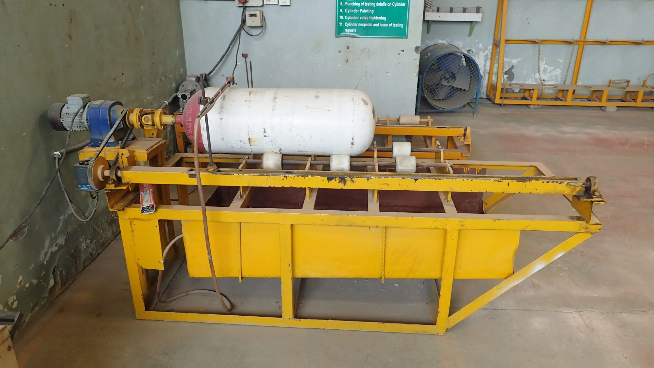 A CNG cylinder mounted on the yellow hydrostatic test rig at the PLS workshop