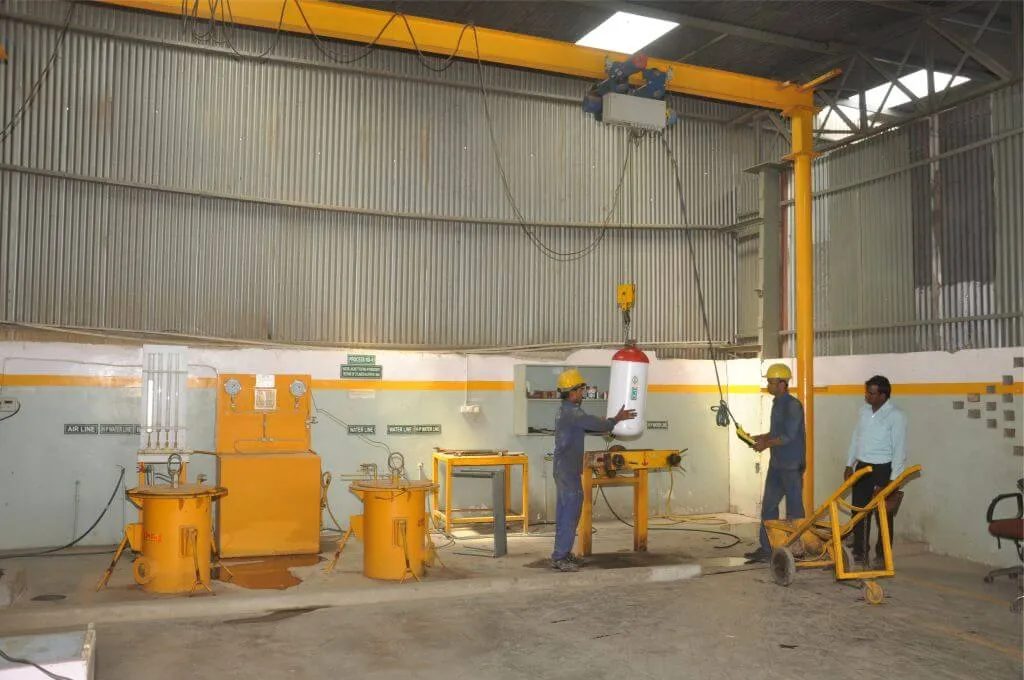 The PLS testing bay with yellow test equipment and technicians at work